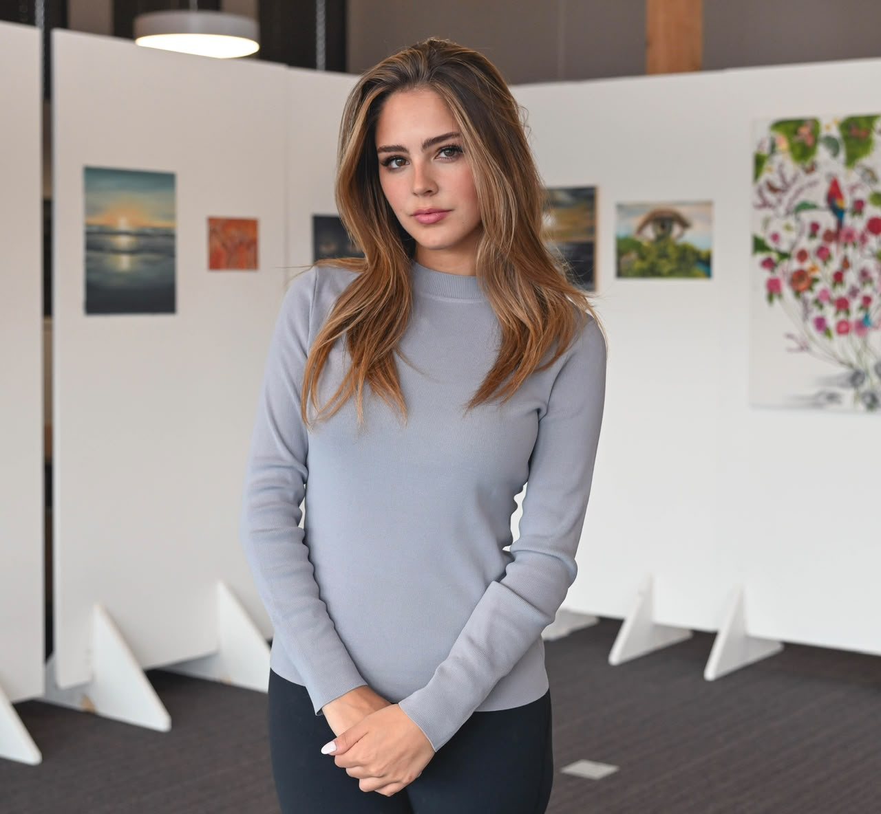 Portrait d'Anemca devant ses œuvres, lors d'une exposition